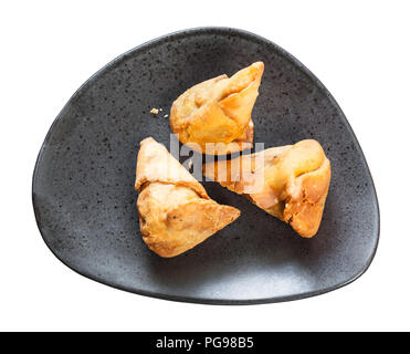 La cuisine indienne - Samosa de légumes poêlée de feuilletage de pois verts et les pommes de terre sur la plaque noire isolé sur fond blanc Banque D'Images