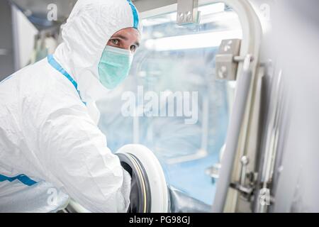 Les techniciens travaillant dans les unités scellées, isolateur stérile dans un laboratoire qui fabrique des tissus pour l'implant. Ces tissus comprennent l'os et des greffes de peau. Banque D'Images