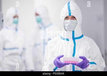 Technicien de laboratoire portant un kit de test à base de cellules dans un laboratoire que les ingénieurs des tissus humains pour l'implant. Ces implants comprennent l'os et des greffes de peau. Banque D'Images