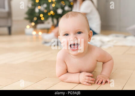 Bébé couché sur le plancher et looking at camera Banque D'Images