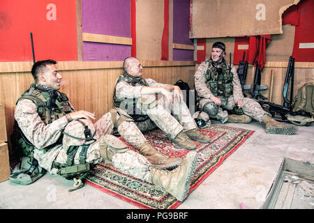 La communication et les soldats se reposant après mission sur outpost Banque D'Images