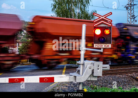 Train de fret passant un passage à niveau avec un feu rouge clignotant, République Tchèque, Europe Banque D'Images