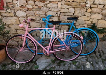 Hum, Croatie - Juillet 29, 2018 : Avis de deux bicyclettes colorées stationné sur un mur de pierre dans la ville de bourdonnement. Hum est connue comme la plus petite ville du monde Banque D'Images