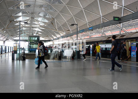 Les banlieusards traversent la plate-forme à une station de métro à Singapour. La station est massive et moderne et est sur le système de transport rapide de masse. Le réseau a cinq lignes distinctes et 119 stations. Banque D'Images