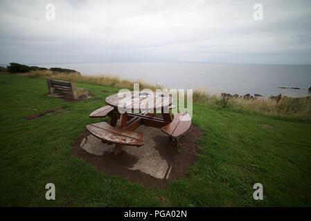 Table de pique-nique ronde par la côte avec une vue magnifique sur la mer (Round table de pique-nique en bois et banc) Banque D'Images