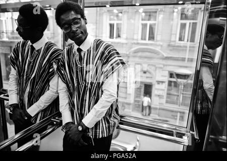 Homme africain en vêtements traditionnels et lunettes à ascenseur ou d'un ascenseur moderne. Banque D'Images