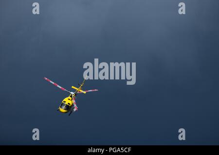 Vol en hélicoptère jaune isolé dans le ciel. Contexte dramatique with copy space Banque D'Images