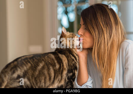 Young Beautiful woman kissing cat avec amour à la maison. Banque D'Images