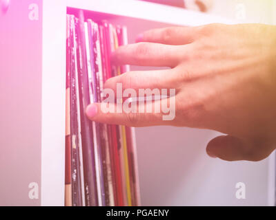 Crate digging collection, personne cueillette à la main la musique disque vinyle à la maison aux tons lumineux rack Banque D'Images