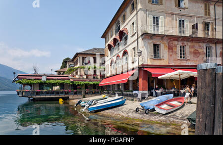 Partie de la façade avec lakefront Ristorante Venus par bateaux des sections locales s'sur la plage de galets d'Orta San Giulio, considéré comme l'un des plus Banque D'Images