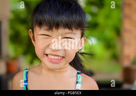 Portrait d'une fille en colère ou girl making face isolé dans un contexte naturel floue Banque D'Images