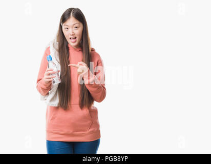 Jeune femme chinoise sur fond isolé portant des sweathshirt sport très heureux pointant avec la main et des doigts Banque D'Images