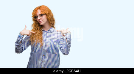 Jeune rousse cherche femme à la confiance avec le sourire sur le visage, faisant soi-même avec les doigts fiers et heureux. Banque D'Images