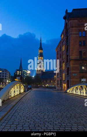 Pont avec des pavés et Hauptkirche Sankt Katharinen la nuit, Speicherstadt, district dans le quartier Hafencity, port de Hambourg, Allemagne Banque D'Images