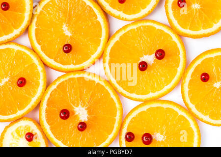 Tranches d'orange avec groseilles rouges sur le dessus sur fond blanc. Banque D'Images