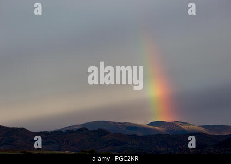 Belle et surréaliste vue d'une partie d'un arc-en-ciel sur certaines collines Banque D'Images