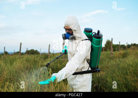 L'agriculture la lutte contre les ravageurs - Jeune travailleur de pulvériser les pesticides organiques sur la culture des fruits plantation. Banque D'Images