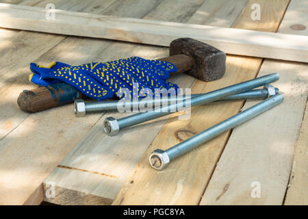 La construction d'un marteau, clous et des gants sur un fond de bois Banque D'Images