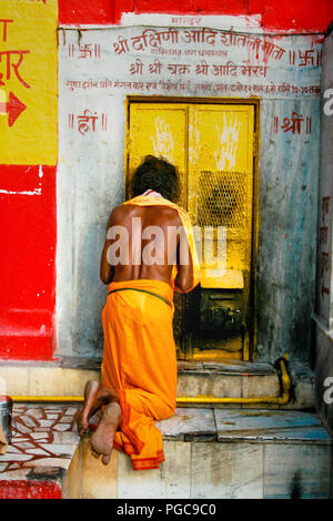 Un homme parays en face de la porte d'un temple à Varanasi, Inde Banque D'Images