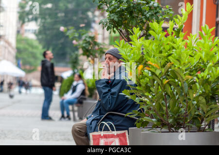 TIMISOARA, Roumanie - 16 MAI 2016 : Man smoking a cigarette et assis sur un banc. De vraies personnes. Vue de derrière Banque D'Images