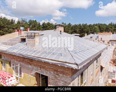 Bâtiment avec isolation thermique externe. nouveau toit métallique en construction. Banque D'Images