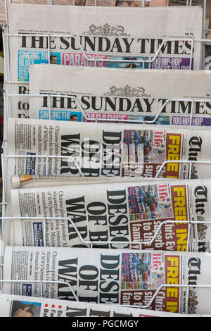 Quotidiens dans un rack dans une boutique de marchands. Le Mail on Sunday et The Sunday Times. Banque D'Images