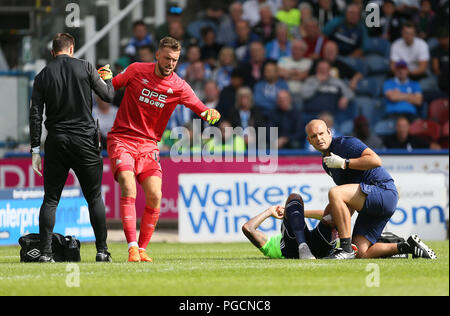 Huddersfield Town gardien Ben Hamer (à gauche) et de la ville de Cardiff Nathaniel Mendez-Laing (droite) reçoivent un traitement pour les blessures après une collision avec l'autre pendant le premier match de championnat à la John Smith's Stadium, Huddersfield. Banque D'Images