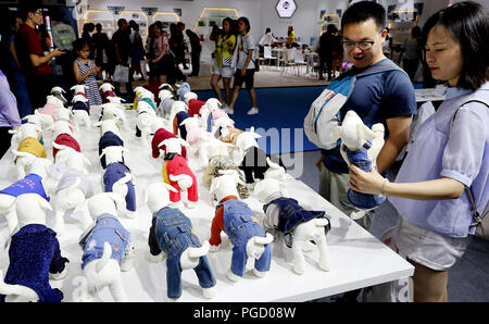 (180825) -- SHANGHAI, le 25 août 2018 (Xinhua) -- Les visiteurs regarder des vêtements pour chiens de compagnie à la 21e Pet Fair Asia à Shanghai, la Chine orientale, le 25 août 2018. L'animal de foire est tenue ici à partir de 22 août à 26. Plus de 1 300 exposants réunissant plus de 16 000 marques de fournitures pour animaux de compagnie ont participé à l'animal de foire. (Xinhua/Fang Zhe) (hxy) Banque D'Images