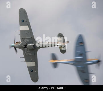 Dunsfold Park, Surrey, UK. 25 août, 2018. Week-end de l'aviation et de l'iconique show automobile à Dunsfold dispose de démonstrations en vol et moderne, classique & supercars. Les changements climatiques peuvent freiner les activités de vol peut le dimanche 26 août, de fortes pluies sont prévues. Hurricane et Spitfire de la Battle of Britain Memorial Flight faire une demande de laissez-passer. Credit : Malcolm Park/Alamy Live News. Banque D'Images