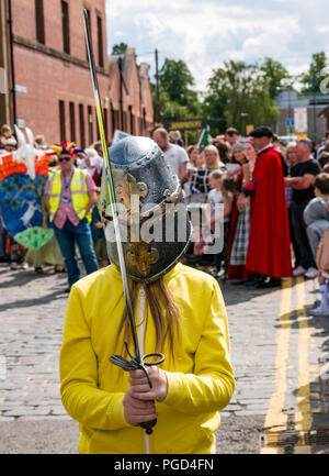 Haddington, Ecosse, Royaume-Uni. 25 août 2018. 700 Haddington médiévale Fête grand jour, la Journée médiévale est le point culminant de Haddington 700 événements qui ont lieu en 2018 pour célébrer l'octroi d'une charte de robert le Bruce à la commune en 1318, confirmant l'Haddington droit de tenir un marché et recueillir des douanes. Une fille pose avec un casque de chevalier et l'épée au début de la parade Banque D'Images