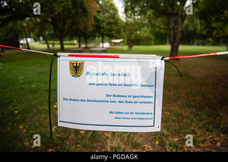Sennfeld, Allemagne. Août 24, 2018. En face de la piscine Sennfeld Lake il y a un panneau indiquant la fermeture du lac. Le faible niveau de l'eau causée par la chaleur de révéler les sites contaminés explosive sous la forme d'armes à sous-munitions, les bombes et les armes trouvées dans les eaux de la Bavière. Crédit : Nicolas Armer/dpa/Alamy Live News Banque D'Images