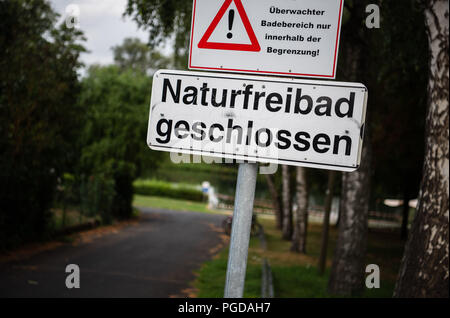 Sennfeld, Allemagne. Août 24, 2018. En face de la piscine Sennfeld Lake il y a un panneau indiquant la fermeture du lac. Le faible niveau de l'eau causée par la chaleur de révéler les sites contaminés explosive sous la forme d'armes à sous-munitions, les bombes et les armes trouvées dans les eaux de la Bavière. Crédit : Nicolas Armer/dpa/Alamy Live News Banque D'Images