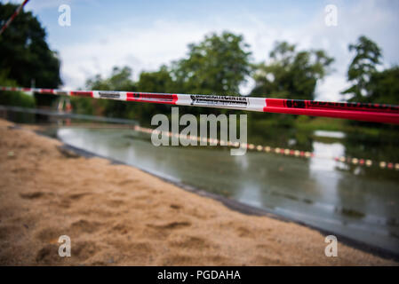 Sennfeld, Allemagne. Août 24, 2018. Un ruban à l'avant du lac de baignade Sennfeld indique la fermeture du lac. Le faible niveau de l'eau causée par la chaleur de révéler les sites contaminés explosive sous la forme d'armes à sous-munitions, les bombes et les armes trouvées dans les eaux de la Bavière. Crédit : Nicolas Armer/dpa/Alamy Live News Banque D'Images