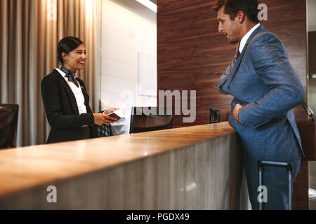 Businessman check-in à la réception de l'hôtel. Femme réceptionniste au bureau avant de parler avec l'invité dans l'hôtel. Banque D'Images