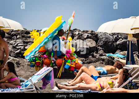 Torre del Greco, près de Naples, Italie - juin 3, 2018 - un homme vend des matelas gonflables et des balles sur une plage Banque D'Images