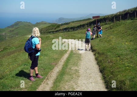 Femme Walker Prendre des photos d'un couple marche sur l'ancien Coach Road entre Lee Bay & Ilfracombe sur le chemin côtier du sud-ouest, Devon, Angleterre, Banque D'Images