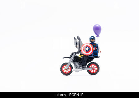 Batman avec Captain America holding balloon équitation moto. Figurines Lego sont fabriqués par le groupe Lego. Banque D'Images