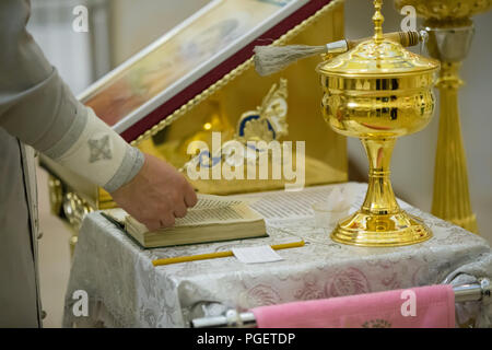 Les mains du prêtre se tournent de la bible Banque D'Images