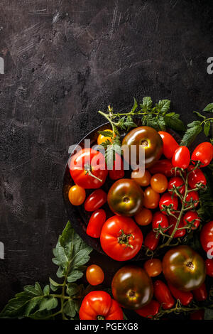 Tomates mûres sur noir grunge background Banque D'Images