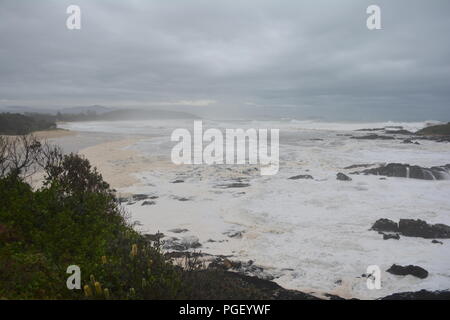 Temps orageux, eau de mer sableuse et mousseuse de sable provenant de vagues sauvages qui se brisent sur la plage de Sawtell en hiver, ciel gris nuageux, Nouvelle-Galles du Sud Australie Banque D'Images