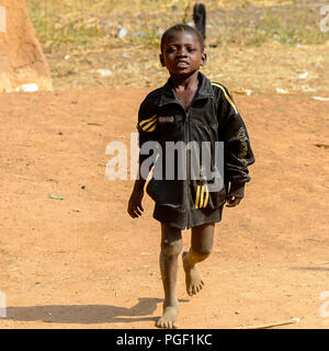 GHANI, GHANA - Jan 14, 2017 : little boy ghanéen non identifiés en blouson noir va dans un village local. Ghana Les gens souffrent de la pauvreté en raison de la mauvais e Banque D'Images