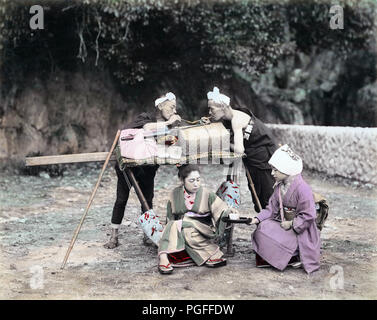 [ Ch. 1890 Japon - porteurs Kago en faisant une pause ] - deux porteurs kago prennent une pause et l'obtention d'un fumer lors de leur client reçoit un plateau d'une jeune femme. 19e siècle vintage albumen photo. Banque D'Images