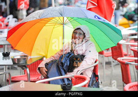 Brighton UK 26 Août 2018 - Ce chien et propriétaire de rester au sec sur le front de mer de Brighton dans le vent et la pluie le mauvais temps balaie la côte sud aujourd'hui, mais les prévisions sont pour elle d'améliorer pour août Bank Holiday Monday Crédit : Simon Dack/Alamy Live News Banque D'Images