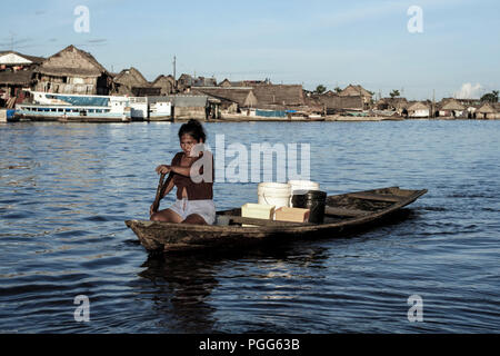 Rembourrage femme canot en bois le long de la rivière dans la région de Belen, Iquitos, Pérou Banque D'Images