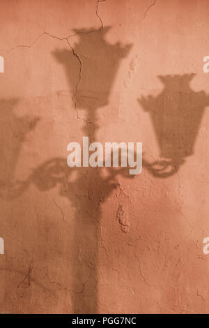 Ombre de Old street lamp post on wall Banque D'Images