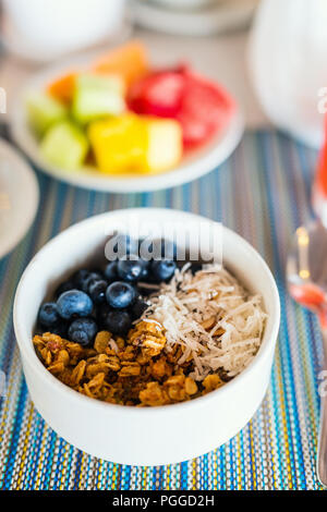 Petit-déjeuner sain bol de granola maison de plusieurs types de céréales, de bleuets frais et flocons de noix de coco Banque D'Images