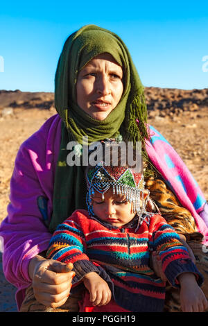 Maroc-DEC 28, 2012 : la mère et l'enfant nomade dans le désert du Sahara Maider région, où les Berbères camp pour faire paître leurs troupeaux. L'enfant porte un traditio Banque D'Images