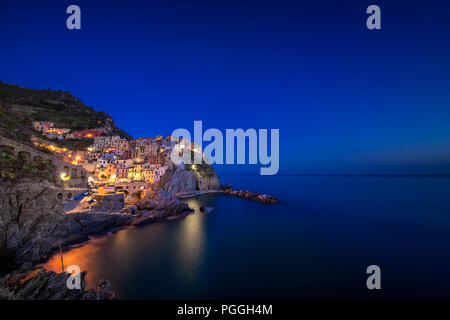 La ville de Manarola, avec éclairage sur, construit sur une falaise au-dessus de la mer Méditerranée et l'un des cinq villages des Cinque Terre près de La Spezia, Italie. Banque D'Images