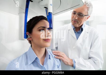 Young woman portrait ayant une vue panoramique sur la radiographie numérique de ses dents avec un médecin d'âge moyen dans le cabinet dentaire. Banque D'Images