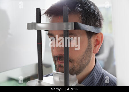 Portrait jeune homme ayant une vue panoramique sur la radiographie numérique de ses dents dans le cabinet dentaire. Banque D'Images